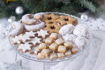 Festive cookies assorted vanilla crescents, cinnamon stars, gingerbreads and cubes and stollen on a festive background.
