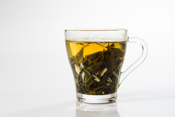 Tea in a glass on a white background. Green or fruit tea.