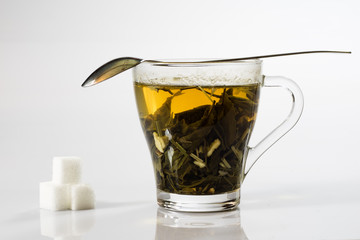 Tea in a glass on a white background. Green or fruit tea.