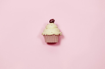 minimalistic pink cupcake figure on pink clean background top view