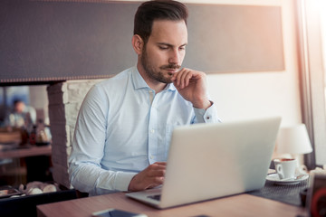  Young man working with laptop in office.