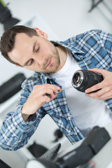 Naklejka premium man mending the camera lens
