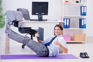 Businessman doing sports in office during break