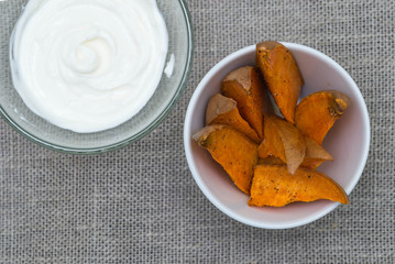 Slices of baked sweet potato with sour cream