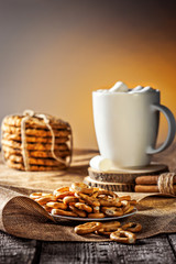 Winter autumn still life  homemade recipe honey ginger oatmeal cookie and bagel, cocoa cup coffee with marshmallow on wooden table kitchen