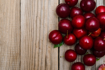fresh plums on wooden background, top view