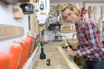 female carpenter smiling at the camera in her workshop