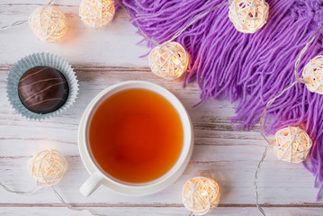 Cup of black tea, plaid, and Christmas garlands glow