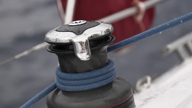 Hand pulls the winch close up slow motion. Rope of marine equipment on sailing vessel.