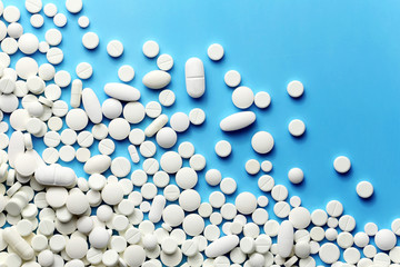 White medicine pills on a blue - 183236103