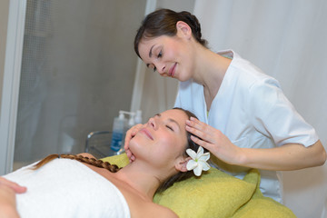 Obraz na płótnie Canvas young attractive girl having head massage at spa resort