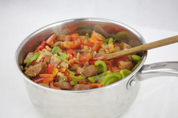 Delicious red souse from sausage, pepper and courgette in the ja