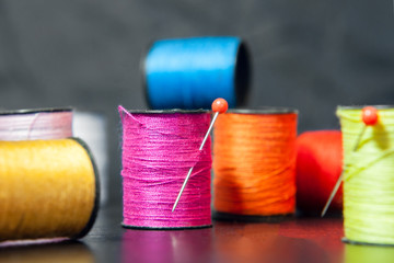 Sewing threads on a wooden background