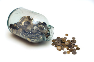 money poured from a glass jar on a white background