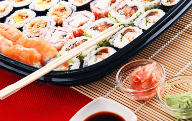 Composition with assorted sushi rolls and bowls of spices