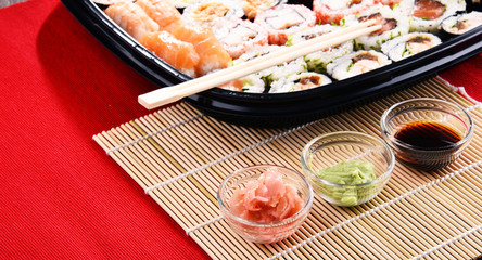 Composition with assorted sushi rolls and bowls of spices