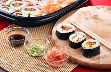 Composition with assorted sushi rolls and bowls of spices