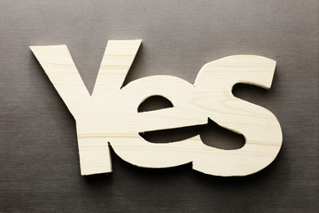 Wood word yes on a grey background - 183238168