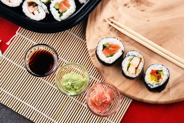 Composition with assorted sushi rolls and bowls of spices