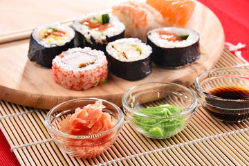Composition with assorted sushi rolls and bowls of spices