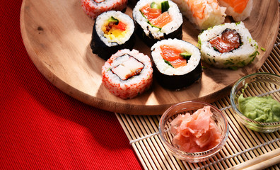 Composition with assorted sushi rolls and bowls of spices