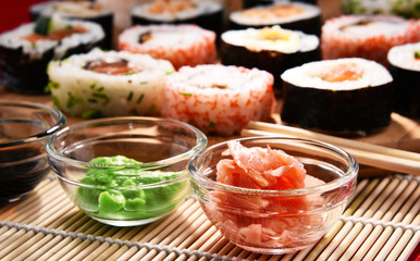 Composition with assorted sushi rolls and bowls of spices