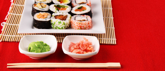 Composition with assorted sushi rolls and bowls of spices