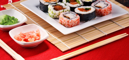 Composition with assorted sushi rolls and bowls of spices