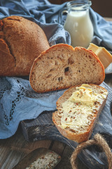 A beautiful loaf of sourdough bread from white wheat on a plate on a linen edge. Homemade pastries. In a rustic style.