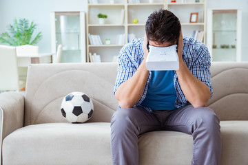 Man wearing virtual reality VR glasses watching soccer football