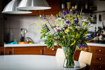 Dry flowers in a glass vase on an old wooden table