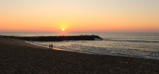 Amazing sunset over a beach with a jetty.