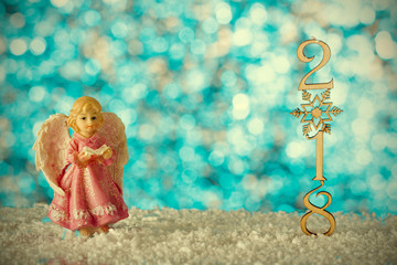 Christmas card with angel. Snow drifts and figures 2018. Blurred background. Effect retro photo.
