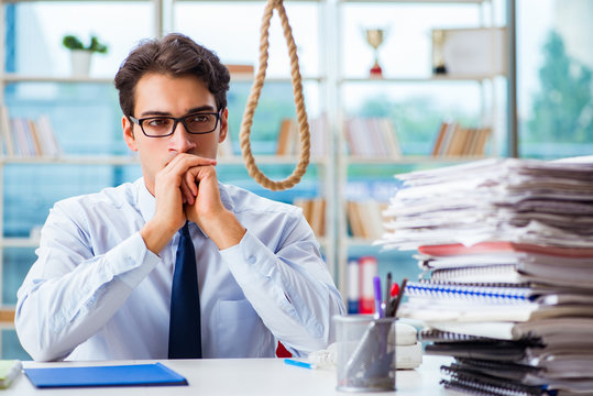 Unhappy businessman thinking of hanging himself in the office