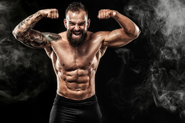 Sportsman muay thai boxer celebrating victory on black background with smoke. Copy Space. Sport concept.