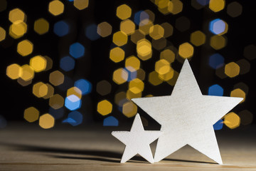 Christmas stars on wooden floor, lights bokeh background