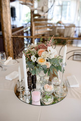 decorated table with flowers and candles on the mirror plate