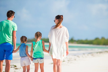 Back view of family of four on the beach