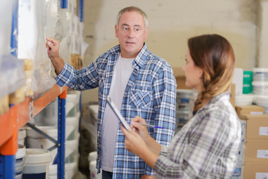 woman and man working in warehouse doing an invertory
