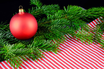 Fototapeta premium Christmas composition with red Christmas ball and fir branches.