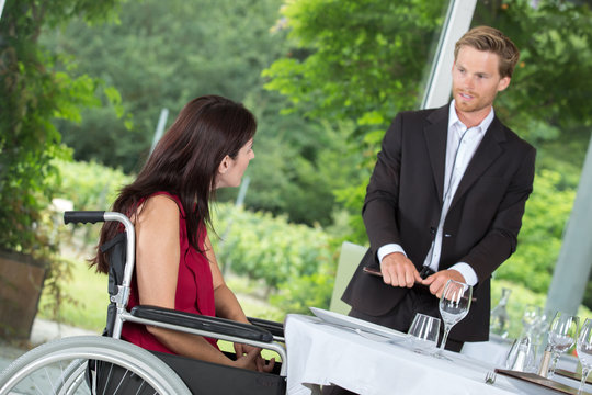 woman in a wheelchair ready to order in a restaurant
