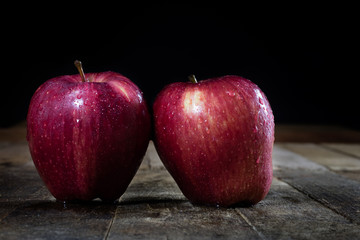 Red tasty wet apple on a wooden table