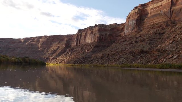 Red rocks float past as the sunrise shines on the Green River.
