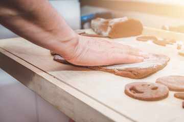 Baking gingerbreads. The family is preparing a gingerbread. The woman kneads the dough. Preparing for Christmas, time for the family, cooking together and baking the concept. 