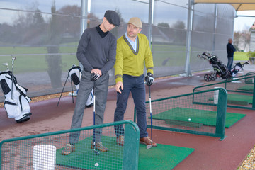 Golfers practicing teeing off