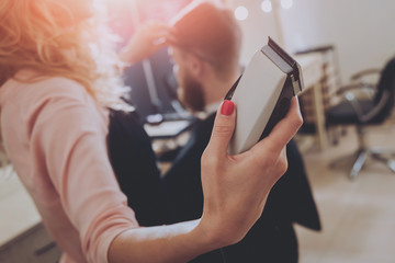 Master cuts hair and beard of men, hairdresser makes hairstyle for a young man. Hipsters