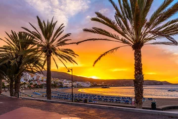 Fotobehang Beach Playa de Las Vistas with sun loungers at sunrise on Tenerife, Canary Islands, Spain © Ekaterina Belova
