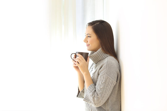 Woman looking away holding a coffee mug