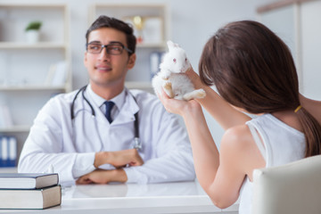 Woman with pet rabbit visiting vet doctor