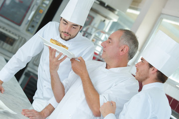 chef preparing food in the kitchen with apprentices